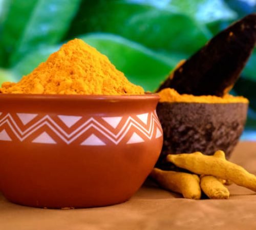 Dry turmeric powder (curcuma longa linn) stone mortar, traditional Indian kitchen Masala for curry, antiseptic antiviral Ayurvedic medicine.